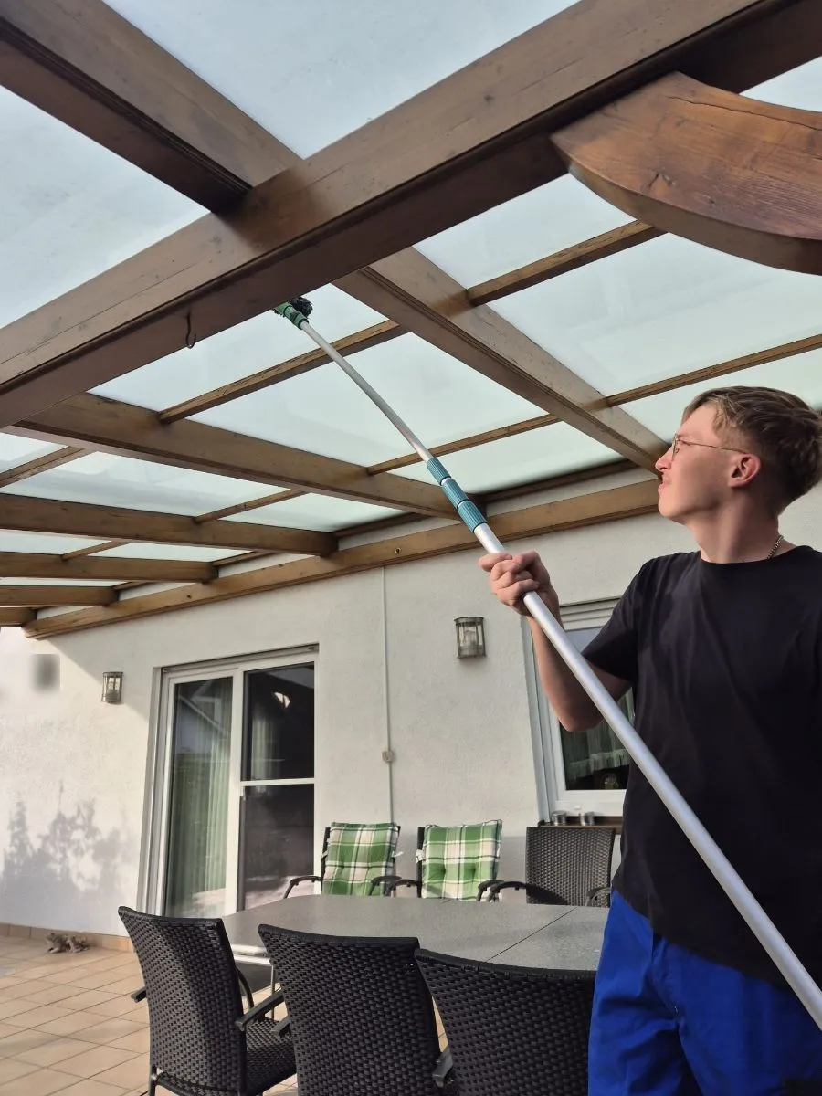 Glasdachreinigung mit Teleskopstange an einer Terrassenüberdachung